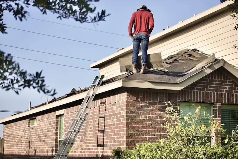 Professional roofer working on a residential roof in Buda